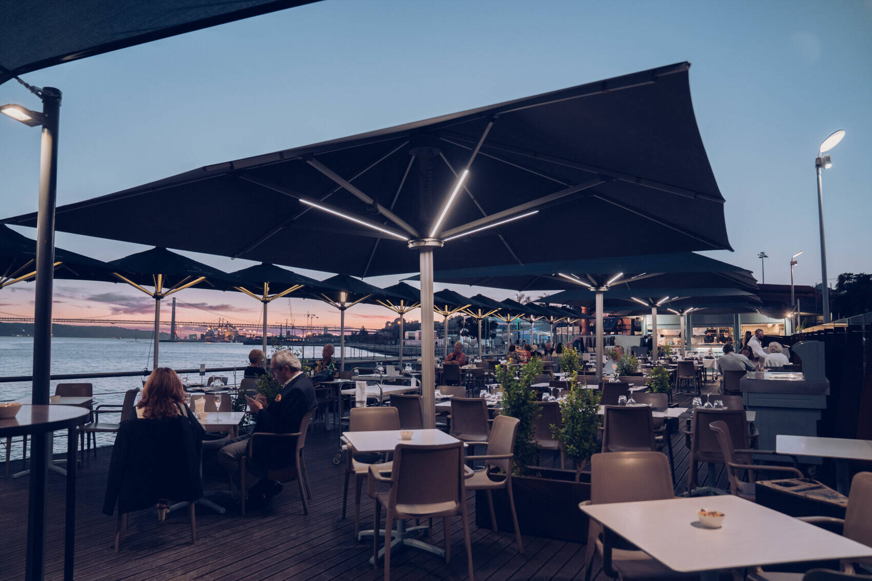 Esplanada do restaurante Monte Mar Lisboa ao pôr do sol com vista para o Tejo